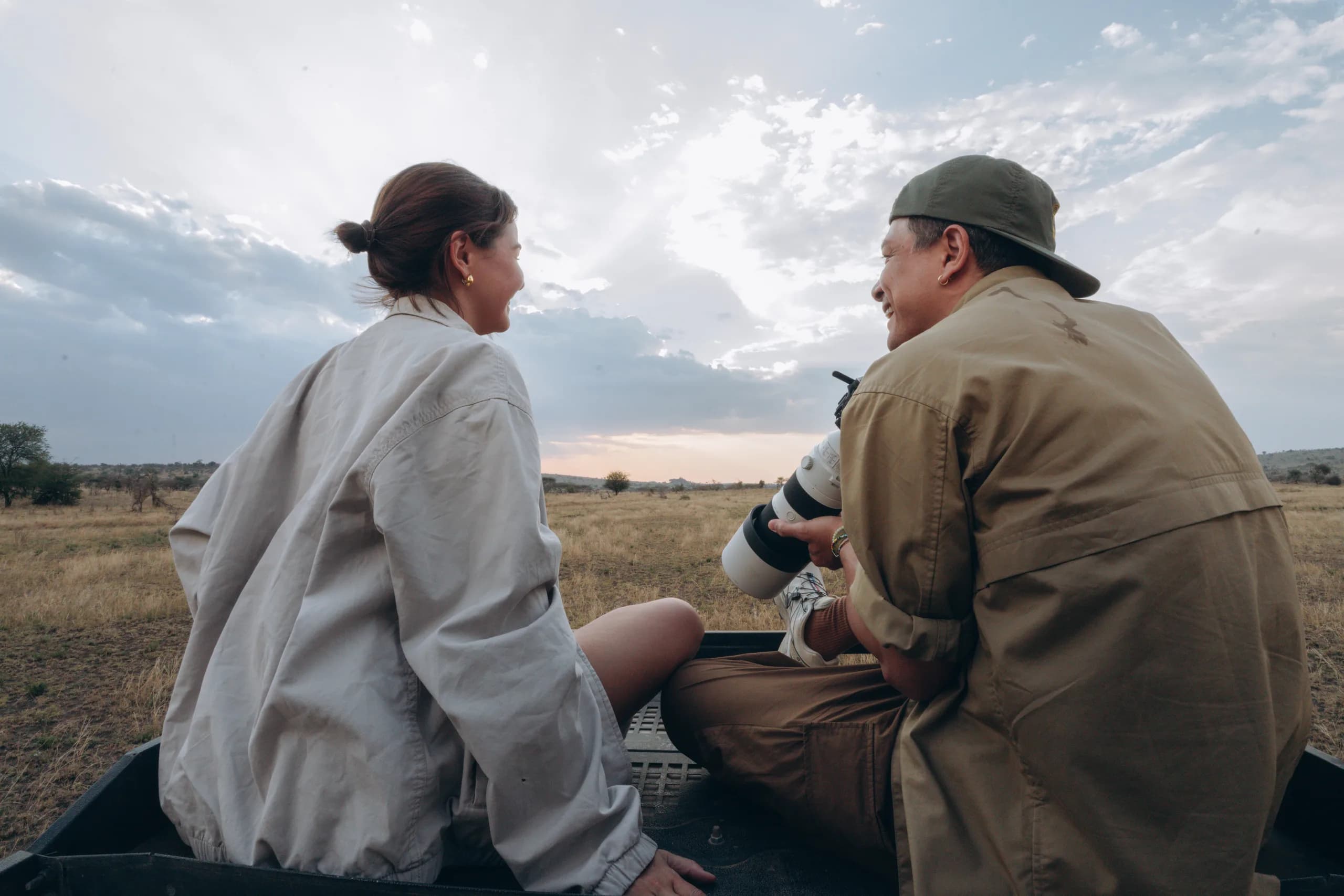 A guide and guest sitting together in the vehicle at sunset